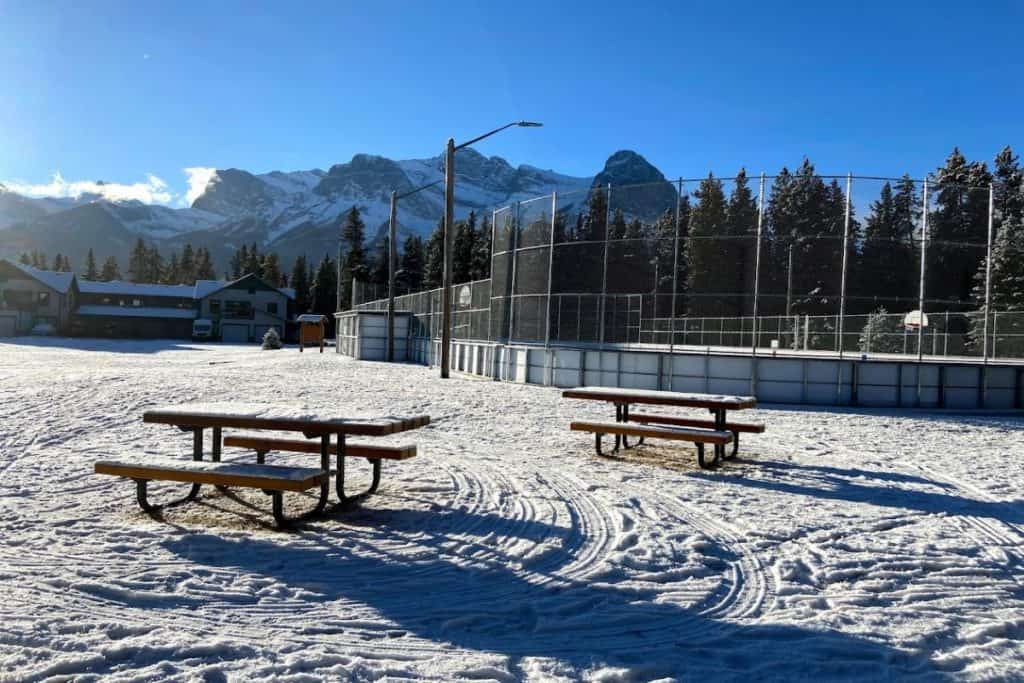 Outdoor Ice Skating Rink In Canmore Alberta Canada With Rocky Mountains In Background