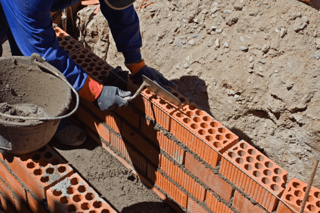 Bricklayer Builds A Wall With Cement, Bricks And A Brick Trowel In Canada For Bricklayer'S Salary In Canada