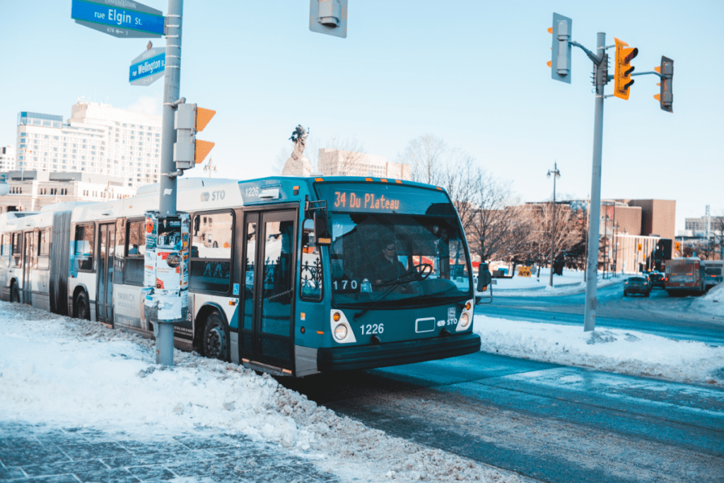 Un travailleur conduit un autobus bleu et blanc un jour de neige au Québec Salaire d'un chauffeur d'autobus au Canada par province