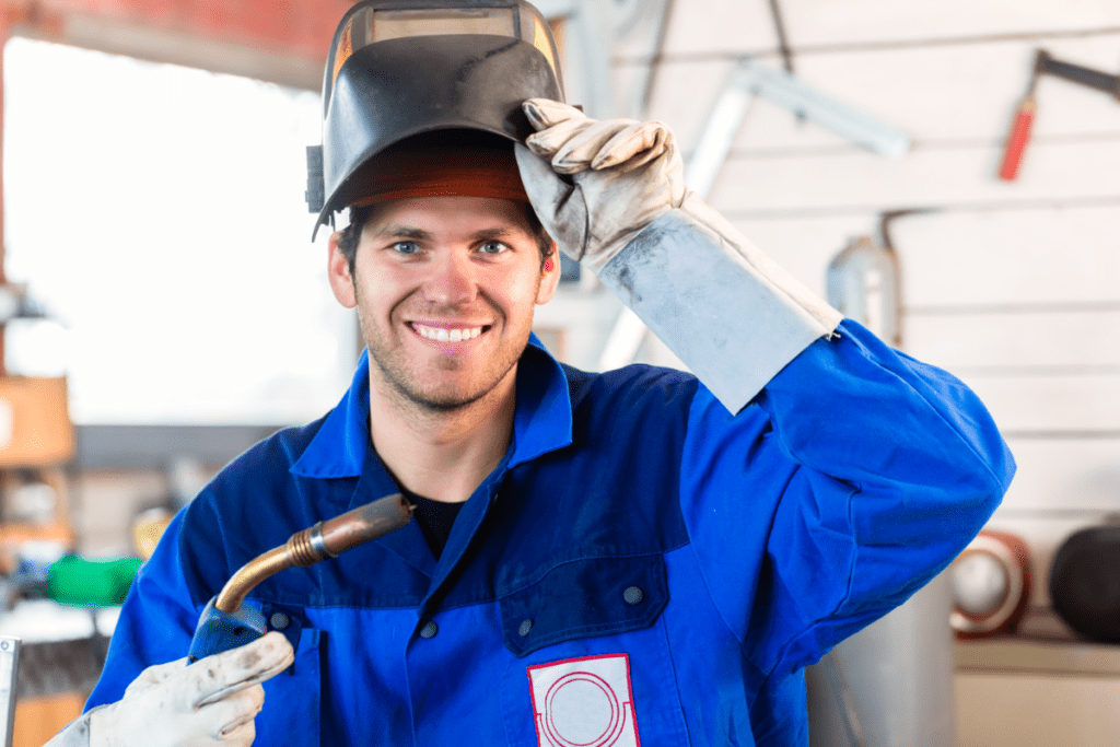 一名微笑的工人拿着一件焊接设备焊工&#039；加拿大各省的工资