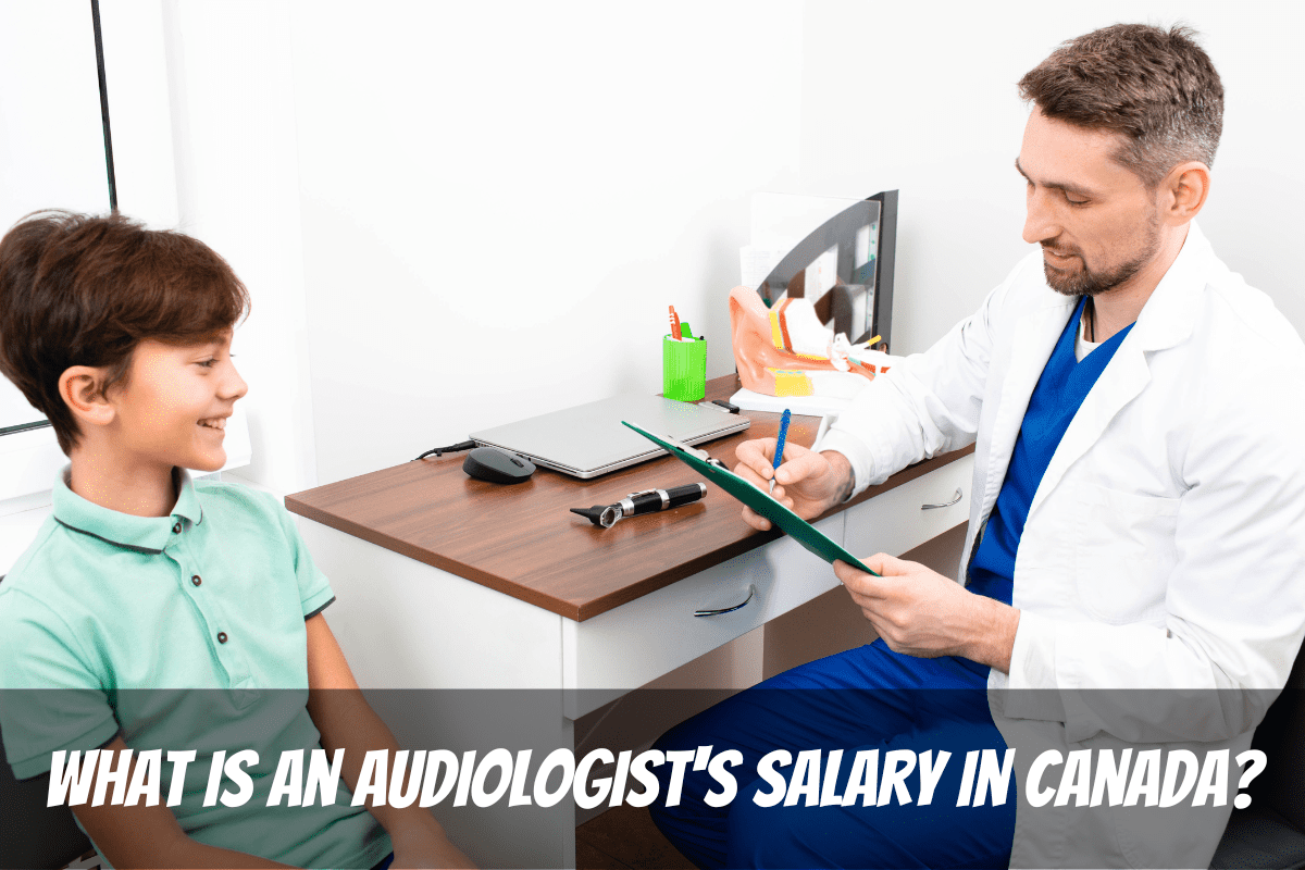 Salario de un audiólogo en Canadá Un hombre sentado en un escritorio ayuda a un niño con su audición