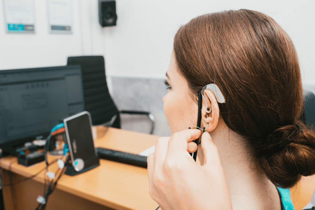 Salario del audiólogo en Canadá A una mujer joven se le coloca un audífono