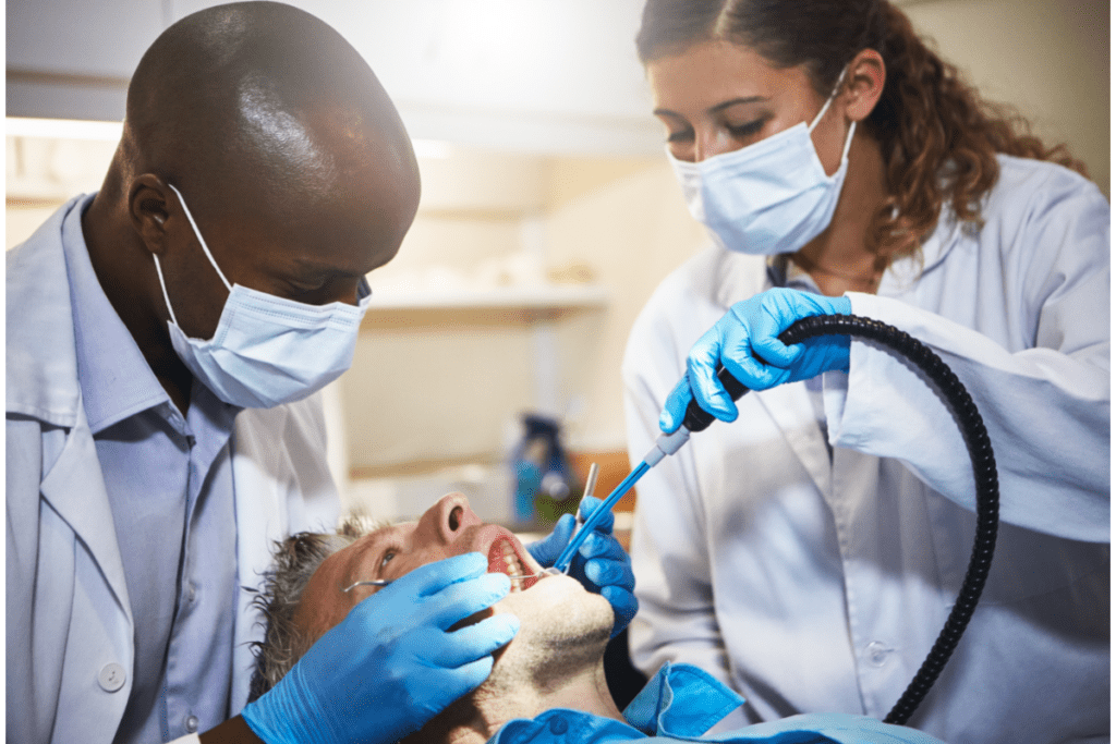 Una ayudante trabaja con un dentista para ganarse el salario de su asistente dental en Canadá