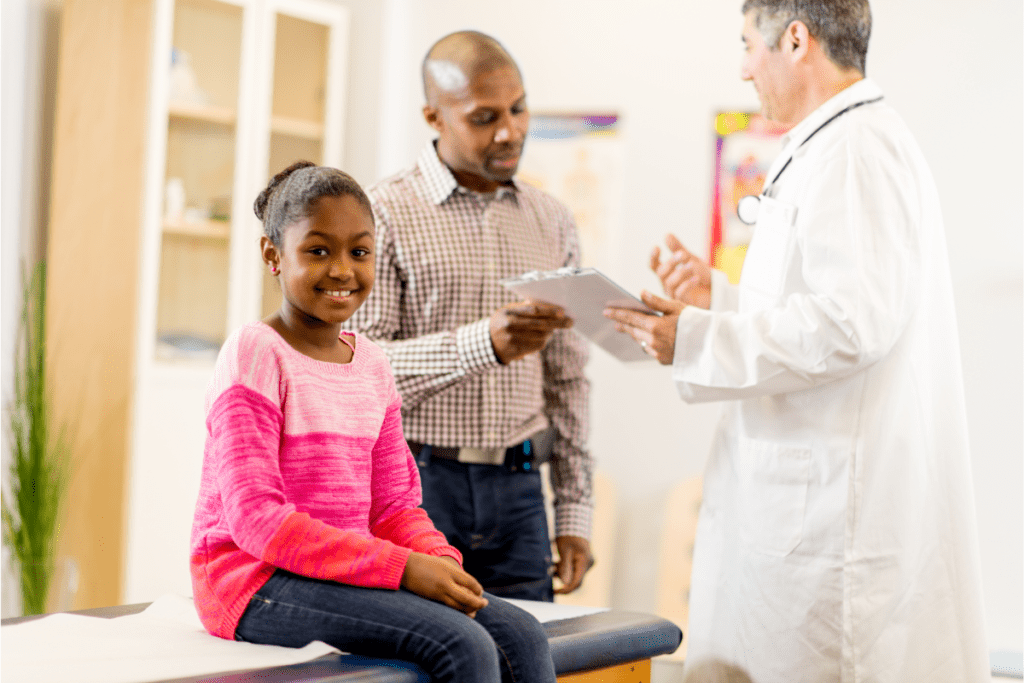Un médecin de famille parle au père d'un jeune patient après sa demande de carte Santé du Québec
