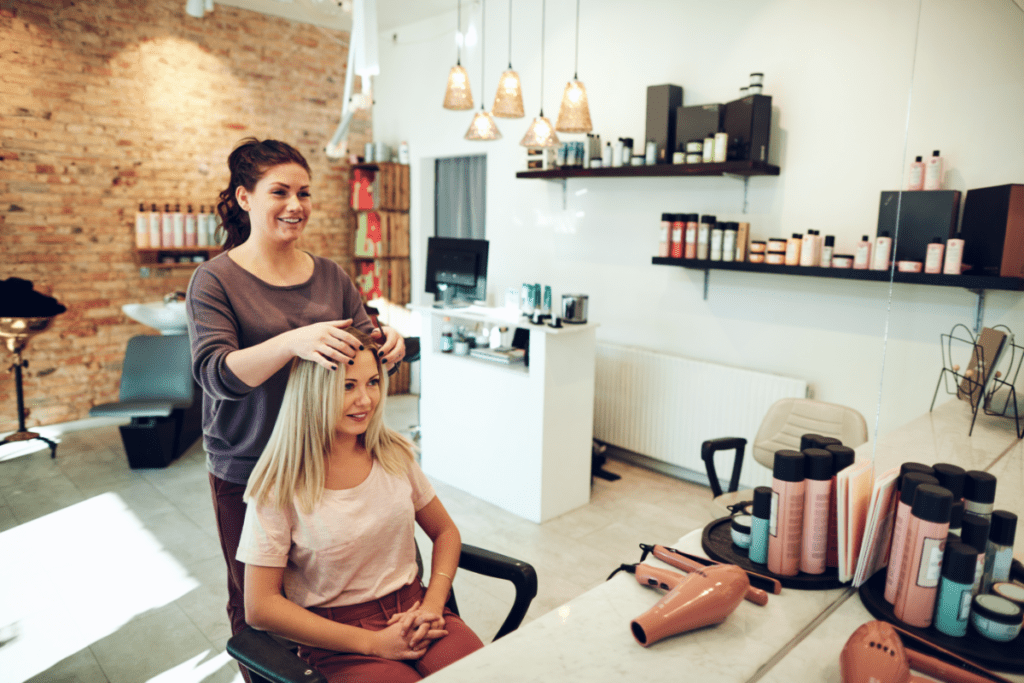 Une femme discute d'un nouveau style de coiffure avec un client pour gagner le salaire d'un coiffeur au Canada