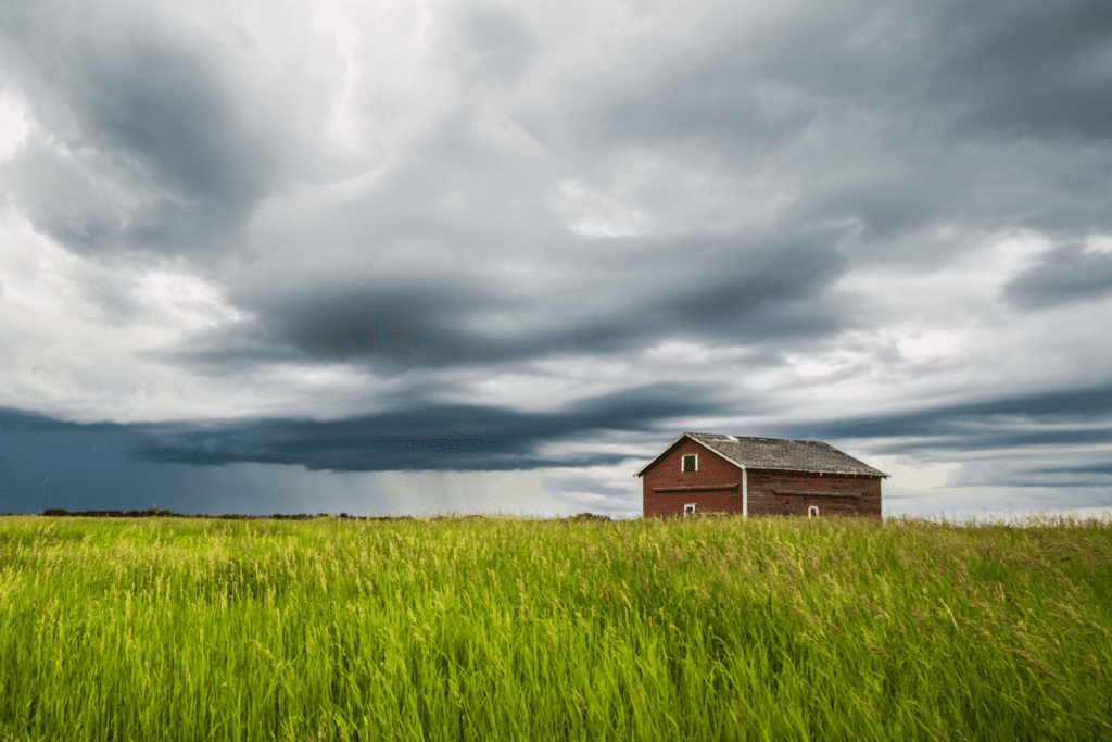 Vista de la pradera de verano de campos de trigo y un granero con un cielo tormentoso Bon Accord Canadá uno de los mejores pueblos pequeños de Alberta