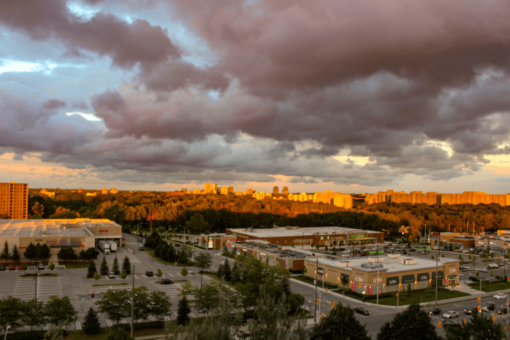 Soleil couchant brille sur les toits de la ville avec de sombres nuages dans le ciel un centre commercial est en premier plan les meilleurs quartiers de London Ontario Canada
