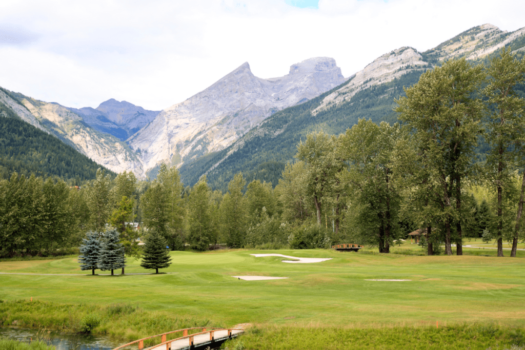 La hierba verde del campo de golf en Fernie con montañas en el fondo, uno de los mejores pueblos pequeños de Bc, Canadá