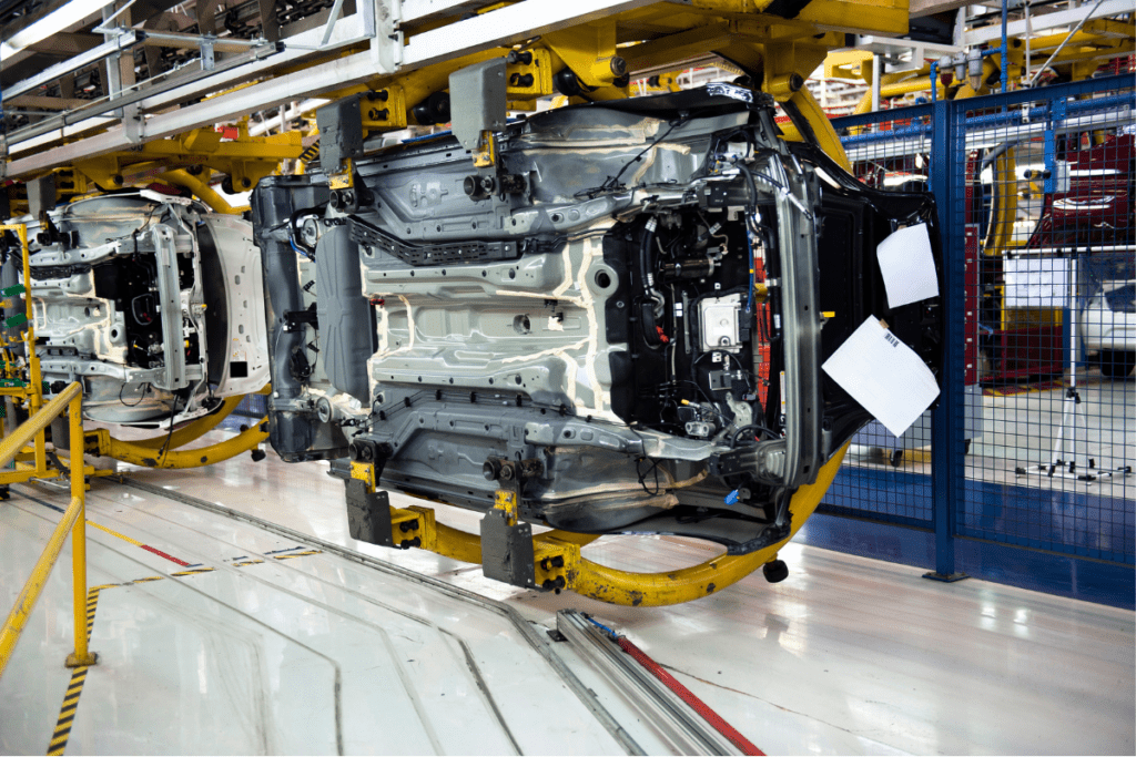 Les voitures se déplacent le long d'une chaîne de production dans une usine de fabrication automobile pour le salaire d'un outilleur-ajusteur au Canada