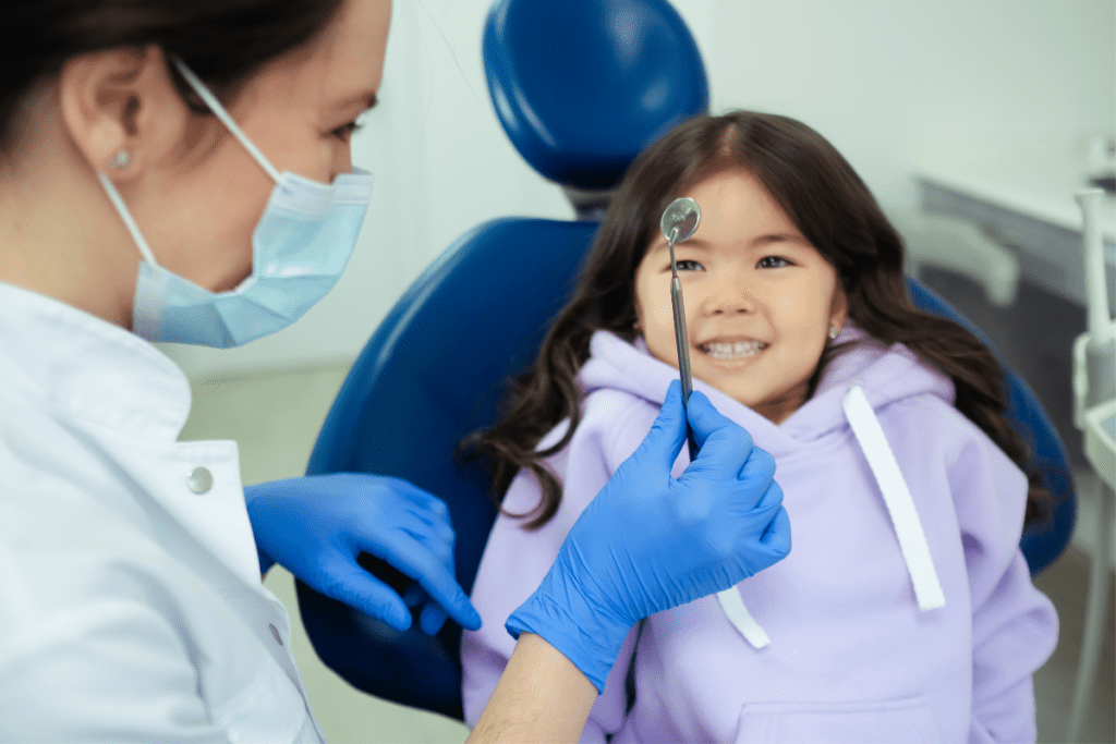 A Dentist Shows A Young Girl In A Dentist'S Chair A Dental Mirror For Dentist'S Salary In Canada