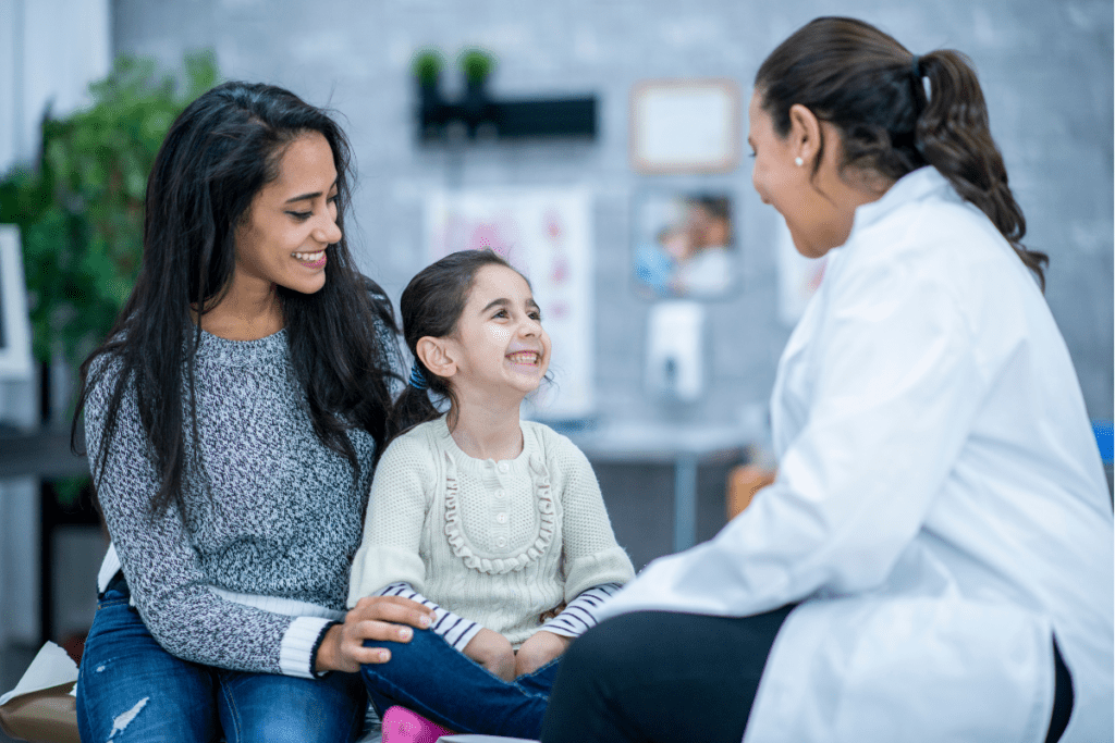 A Smiling Female Doctor Talks To A Young Patient And Her Mother For Family Doctor'S Salary In Canada