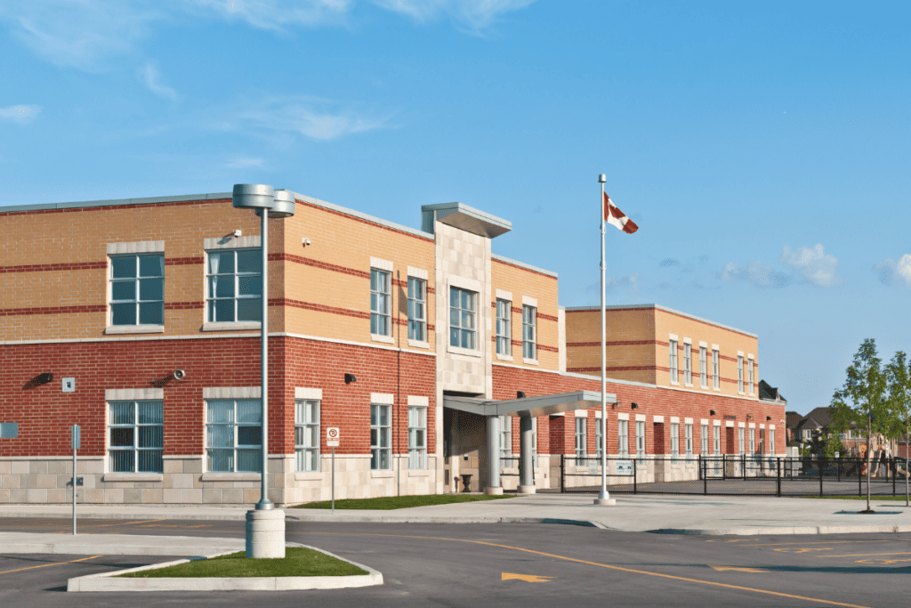 A New Canadian Elementary School With The Canadian Flag Flying For Teachers' Salary In Canada