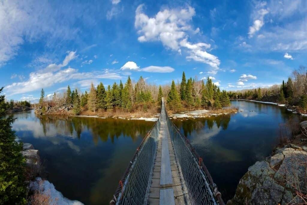 A Suspension Bridge At Pinawa Goes Across Water To An Island On A Sunny Day One Of The Best Reasons To Move To Manitoba